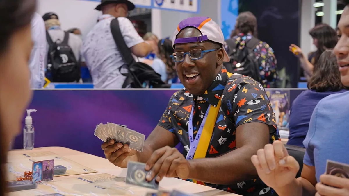 Joueurs de Disney Lorcana au stand Ravensburger de la D23 2026, où le jeu en ligne a été annoncé